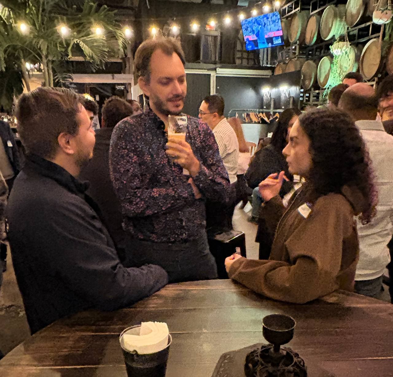 Three guests mid-conversation, drinks in hand